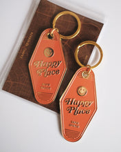 Load image into Gallery viewer, Two &#39;Happy Place&#39; keychains on a textured surface
